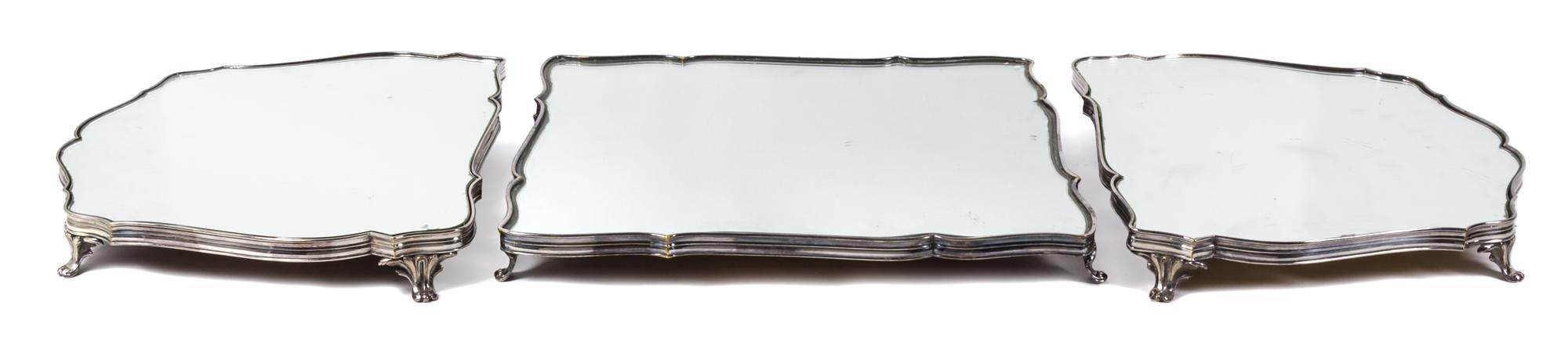 A French Silver-Plate Surtout de Table, Christofle & Cie, Paris, in three parts, each mirrored and raised on four foliate scroll feet.