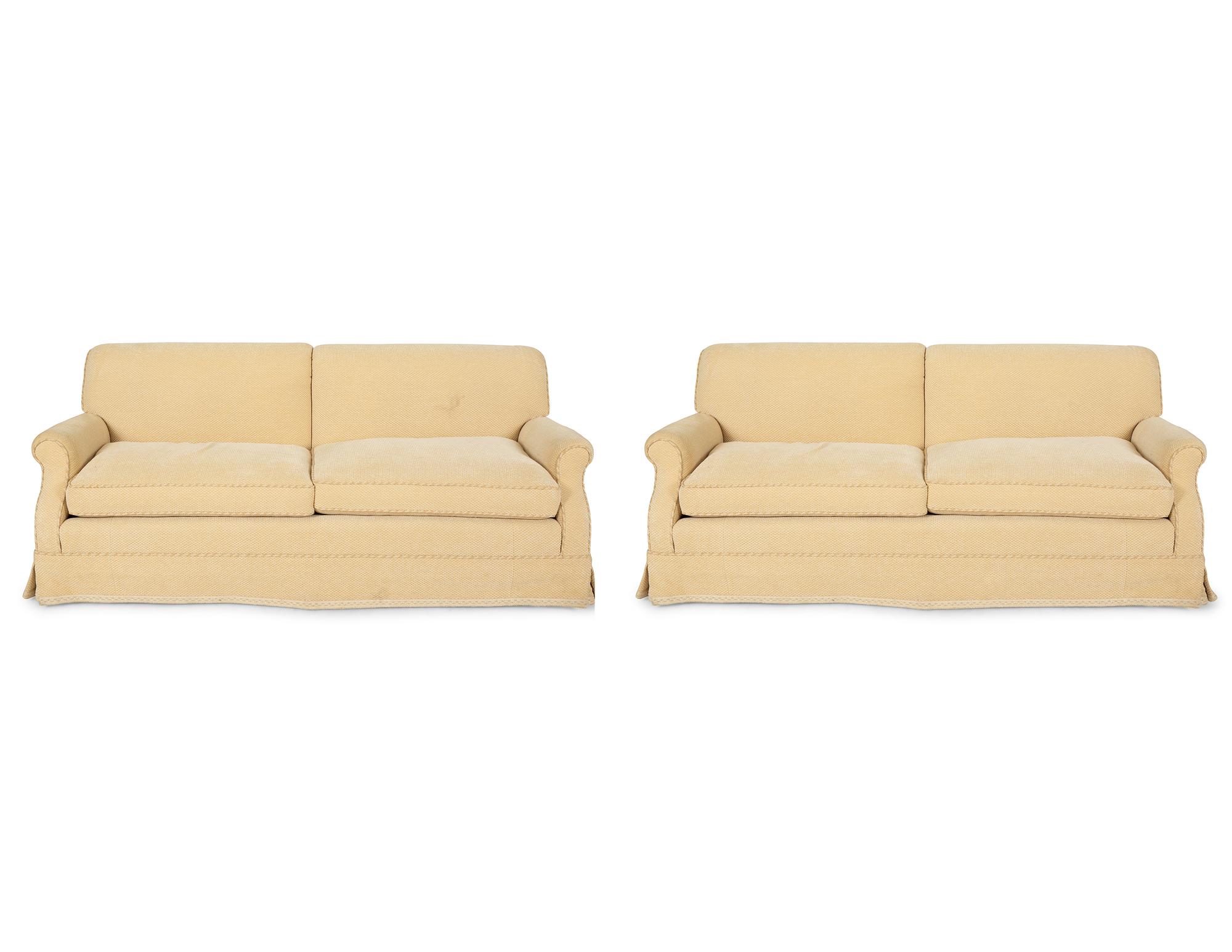 A Pair of Ivory Upholstered Three Cushion Sofas — 20th Century