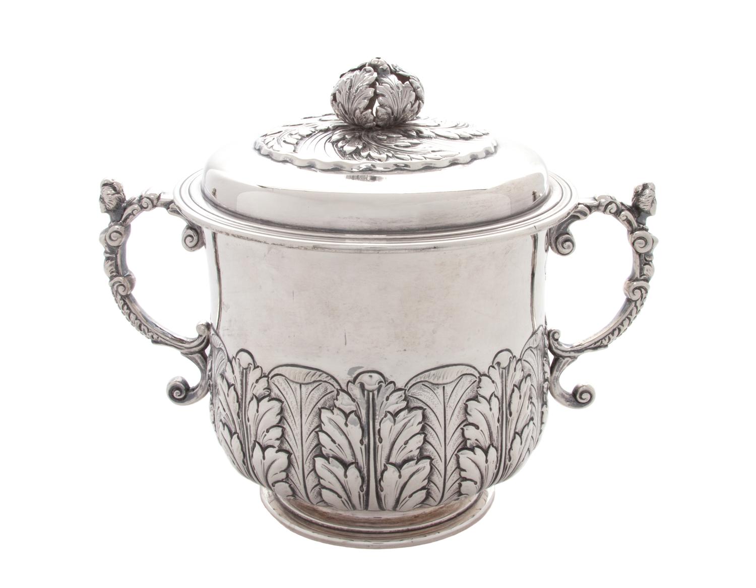 An English Silver Covered Sugar, London, 1917, with applied S-scroll handles, an open acanthus finial and a band of acanthus rising fro