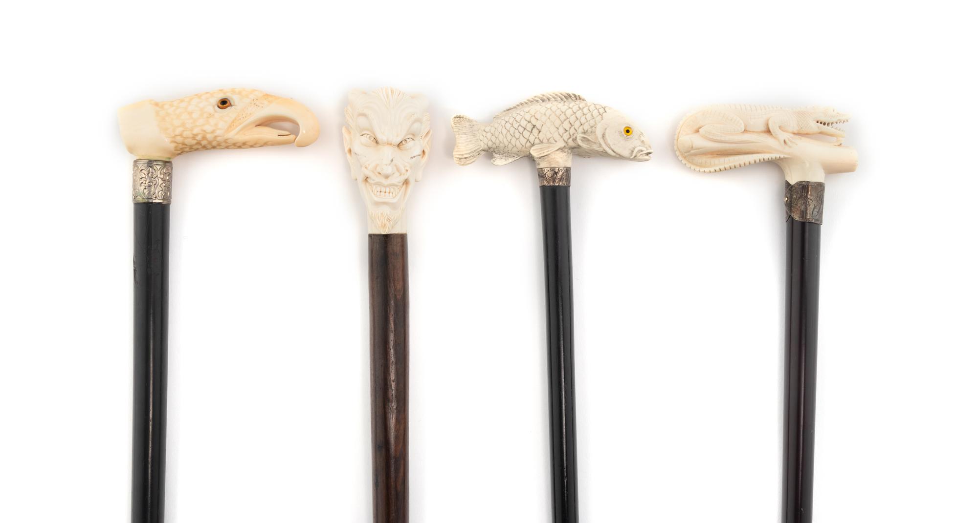 A Group of Four Carved Resin Walking Sticks