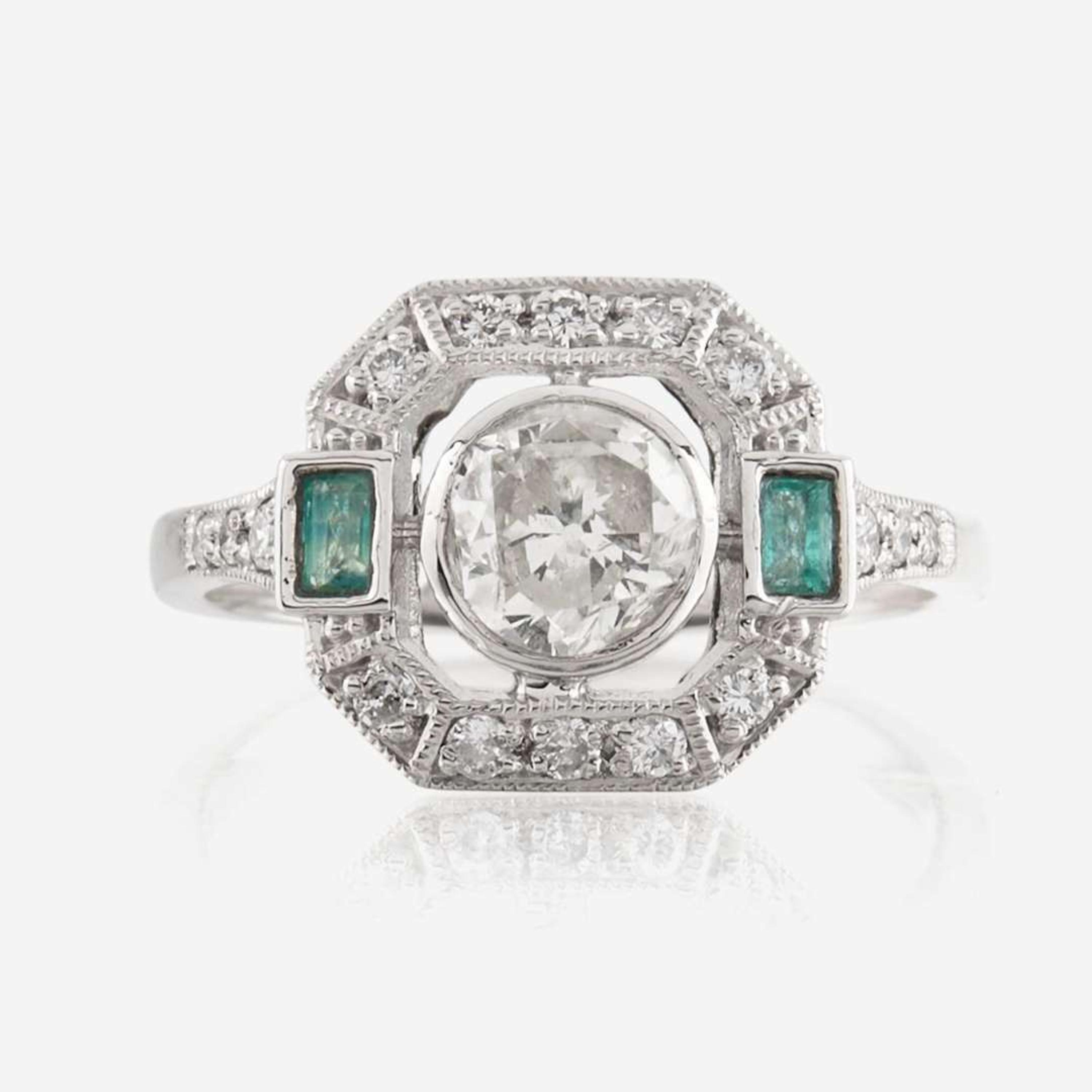 A diamond, emerald, and platinum ring