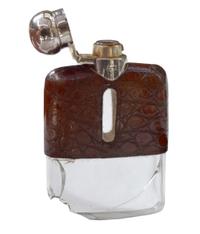 A Set of Three Silver and Stamped Leather Hip Flasks Left: 2.25" x .5" x 3.75" tall: Middle: 3" x 1" x 5" tall: Right: 3.25" x 1" x 5.5 — England, Circa 1925-1940
