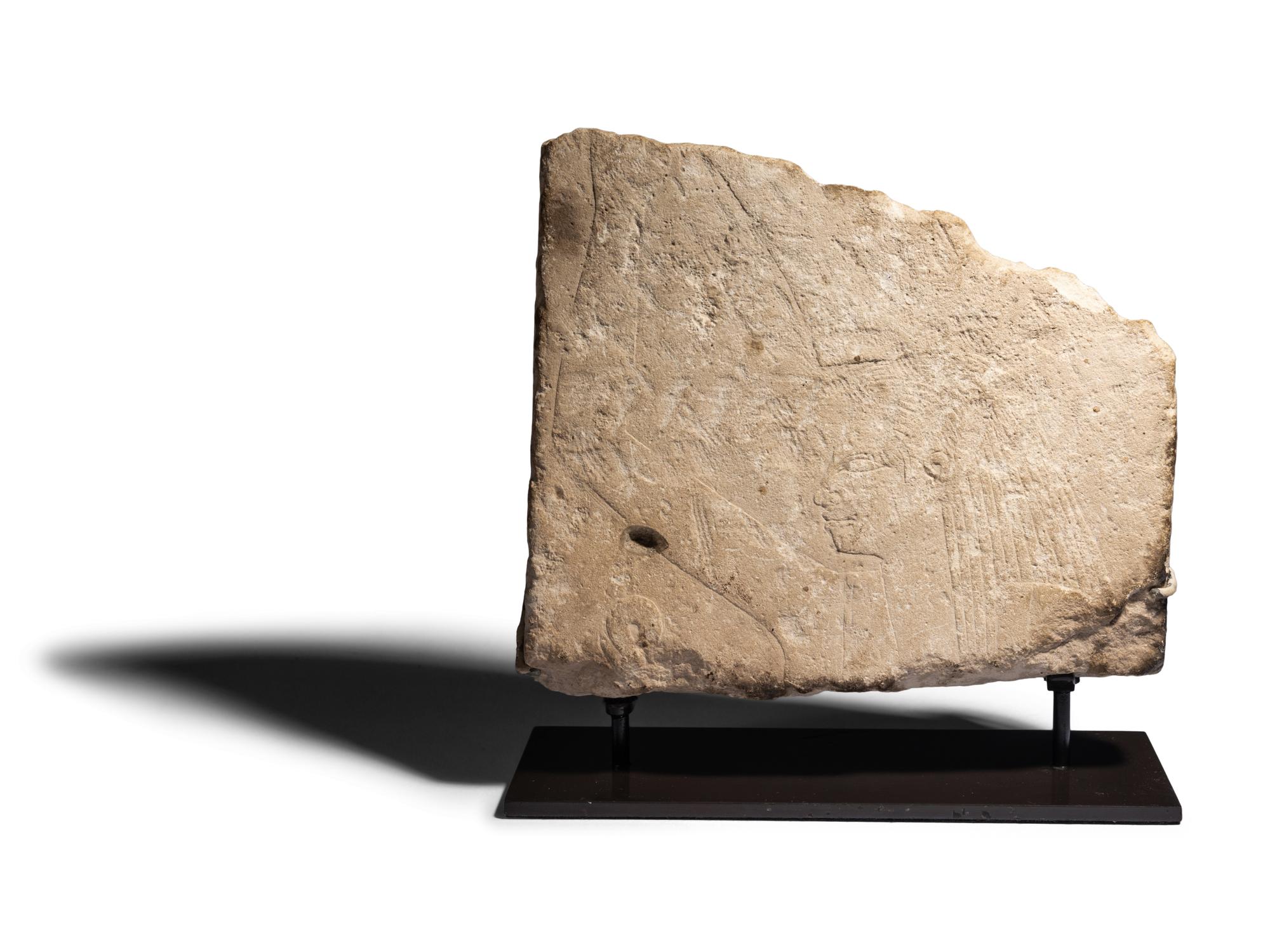 An Egyptian Limestone Relief Fragment with Serving Woman