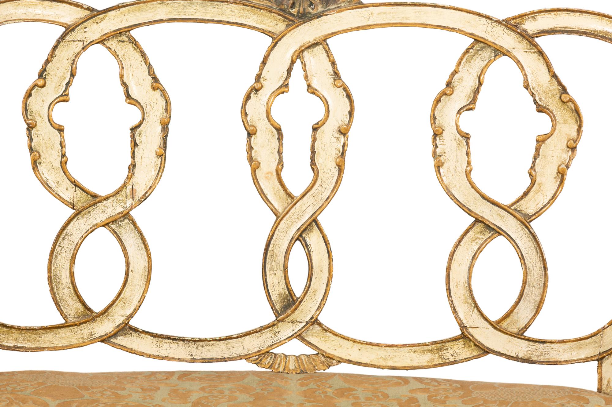 An Italian Painted and Parcel Gilt Settee with Fortuny Upholstery