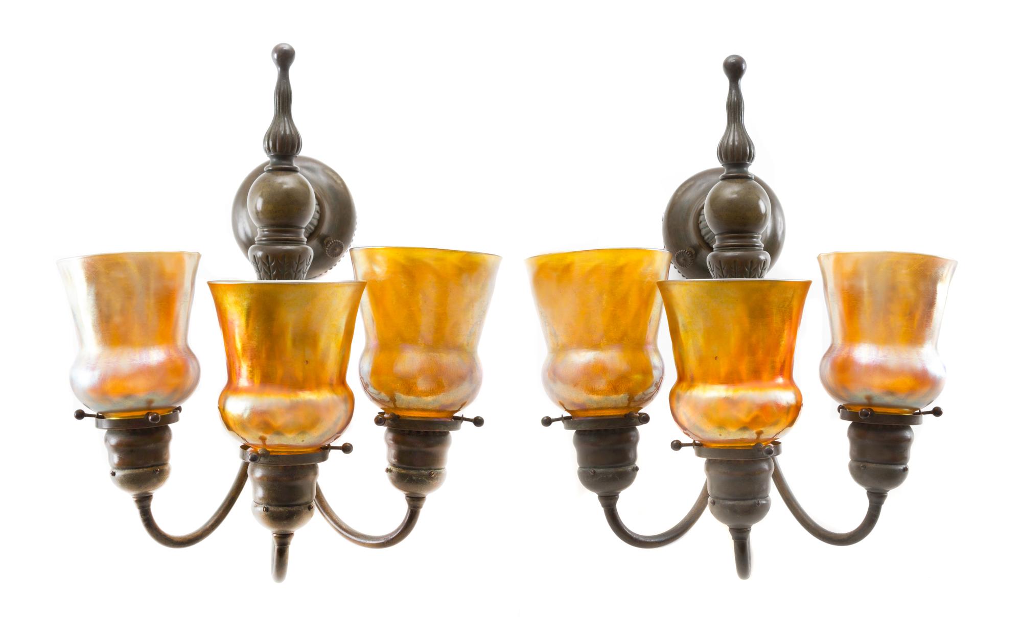 A Pair of Tiffany Studios Favrile Glass and Bronze Three-Light Sconces Height of shades 4 1/2 inches, height overall 16 inches.