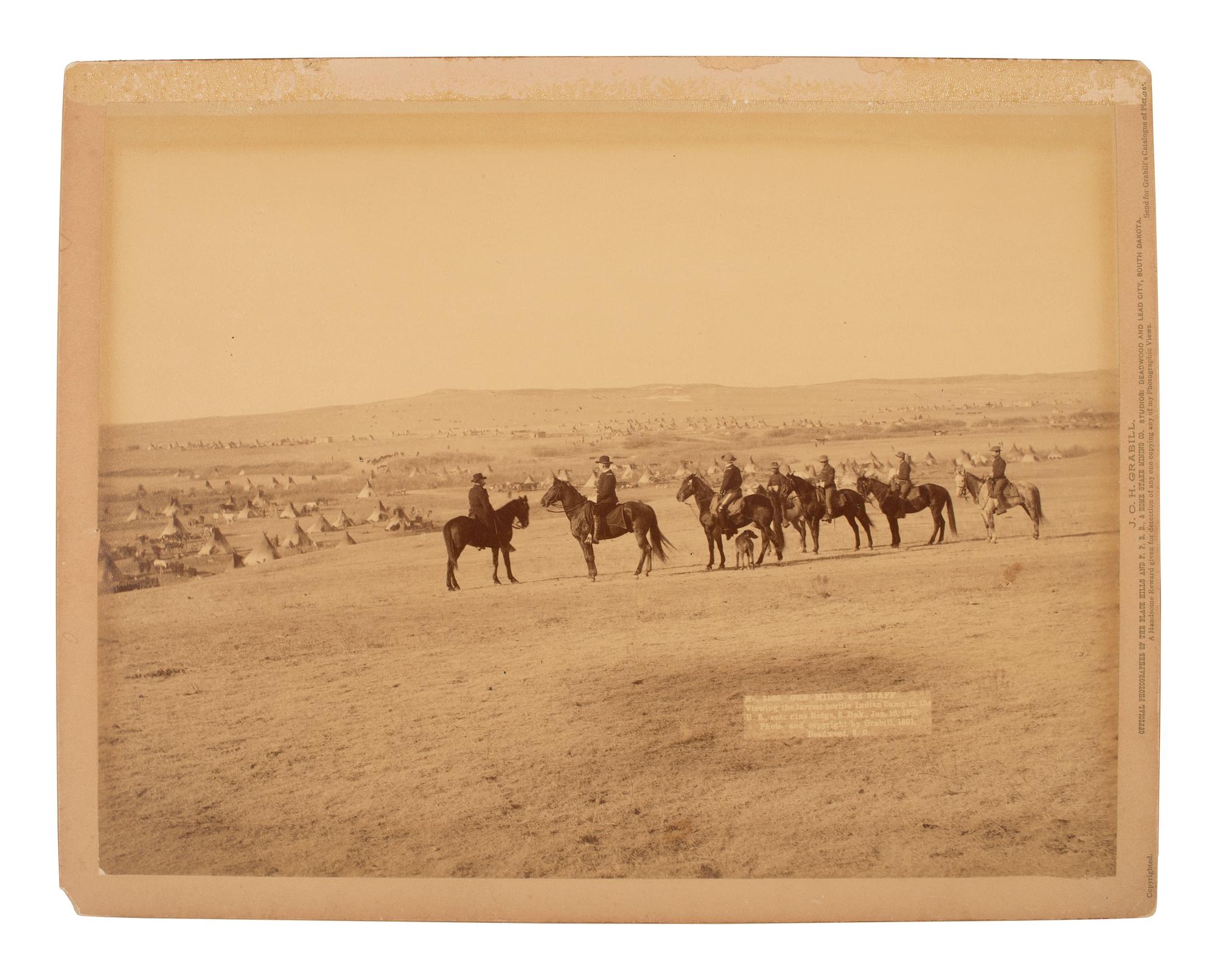 GRABILL, John C.H. (1849-1903), photographer. Photograph of General Nelson Miles and his staff viewing a Lakota camp after Wounded Knee, January 1891.