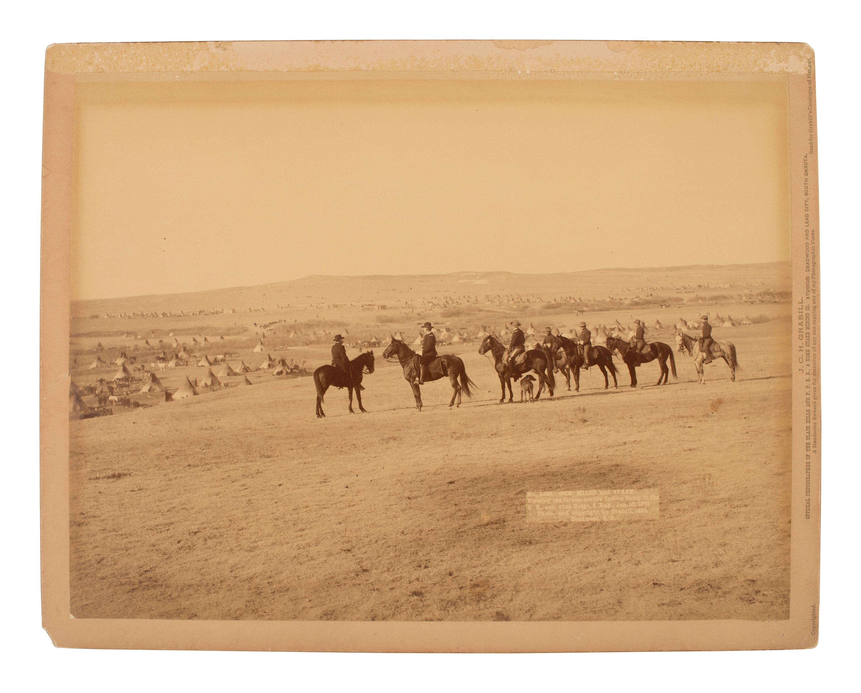 GRABILL, John C.H. (1849-1903), photographer. Photograph of General Nelson Miles and his staff viewing a Lakota camp after Wounded Knee, January 1891.