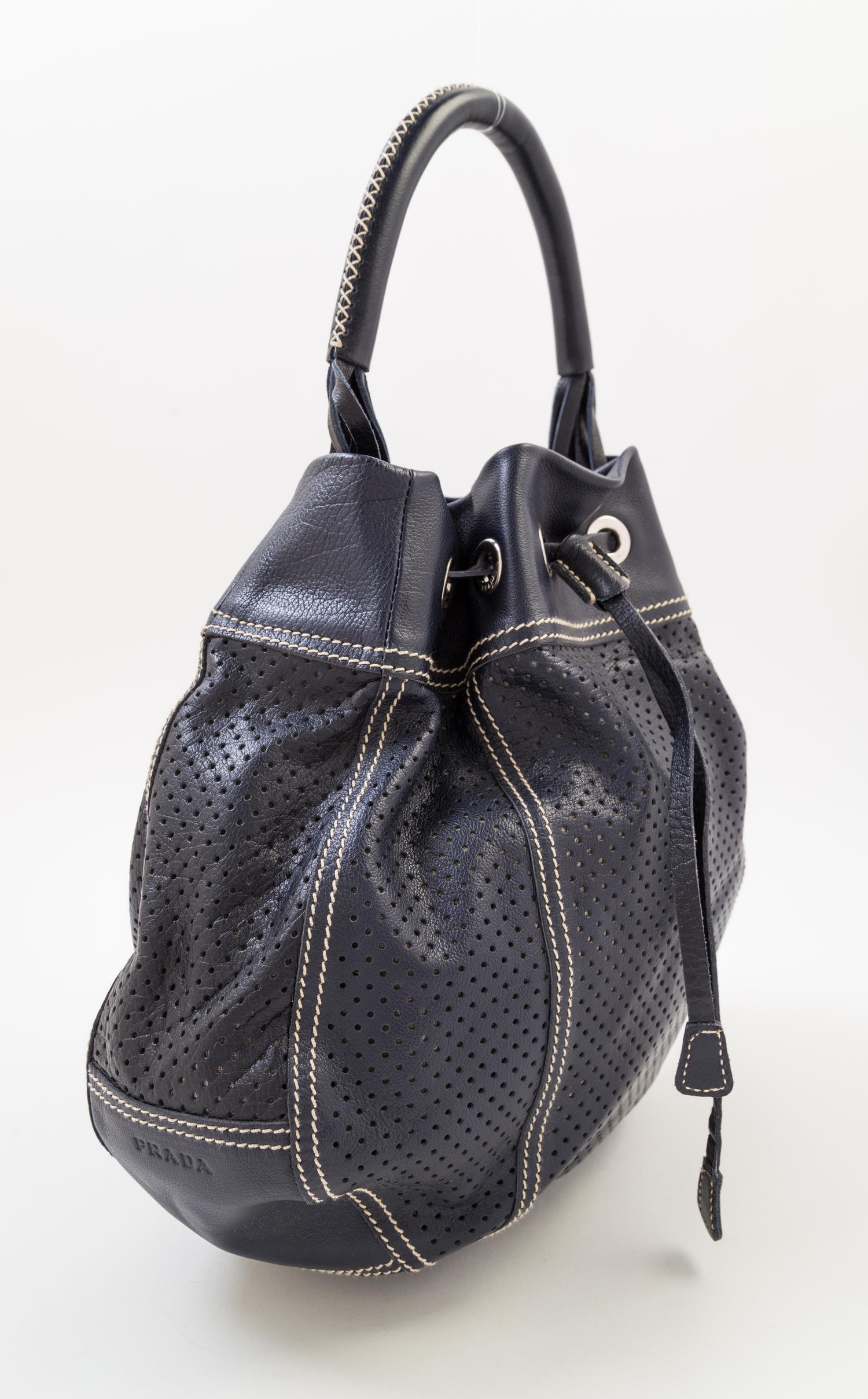 A Prada Navy Perforated Leather Bucket Bag, 13" x 12" x 4"; Handle drop: 4.5".