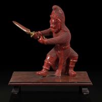 An unusual and finely-carved cinnabar lacquer figure of a warrior 朱漆武士像