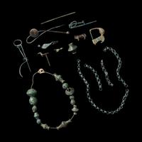 A Group of European and Luristan Bronze Fragmentary Fibulae, Beads, and Chains