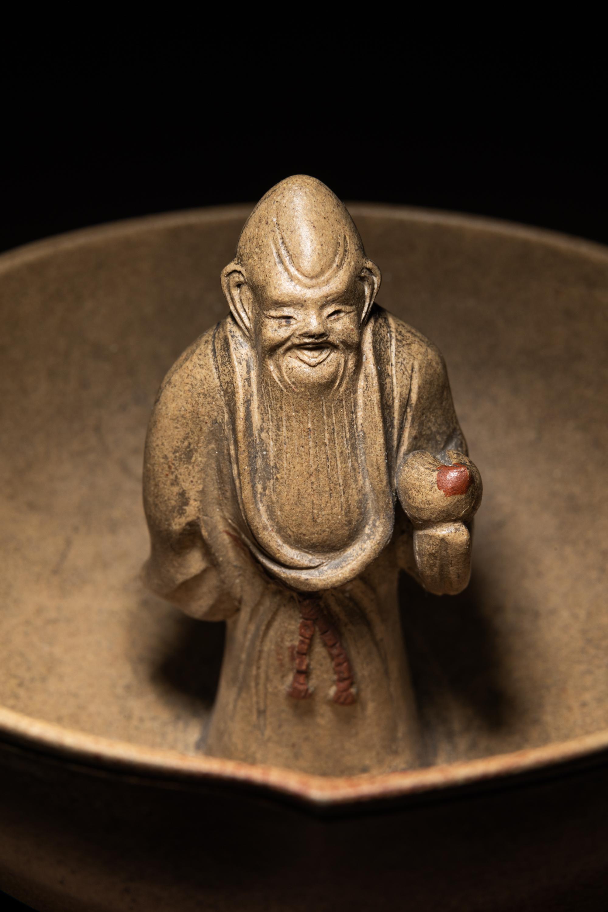 A Rare Yixing Peach-Form 'Figure' Puzzle Cup with Impressed Seals 'Chen', 'Mingyuan' and Wood Stand 陳鳴遠款醉翁桃形公道杯