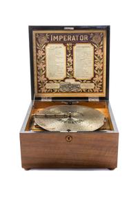 An Imperator Walnut Disk Music Box, Heigth 8 3/8 x width 13 5/8 x depth 13 1/2 inches.