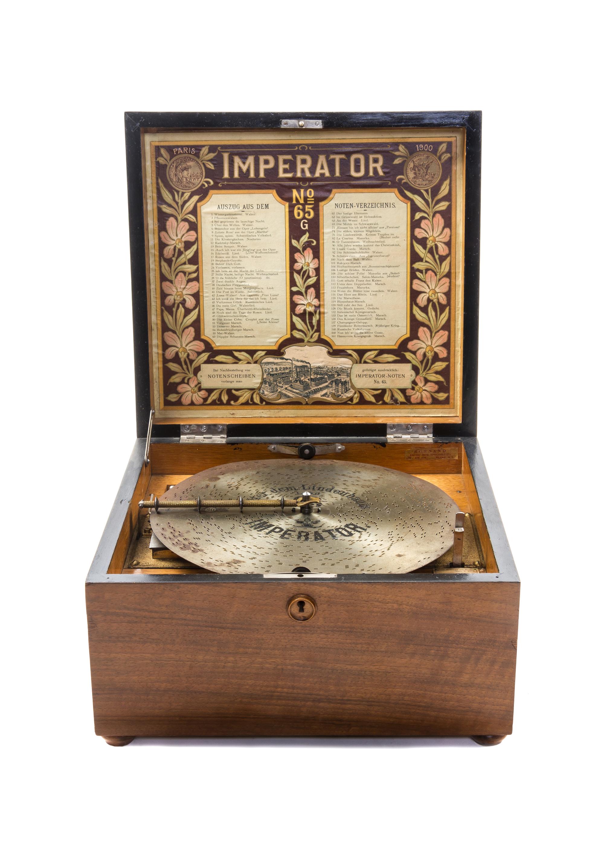 An Imperator Walnut Disk Music Box, Heigth 8 3/8 x width 13 5/8 x depth 13 1/2 inches.