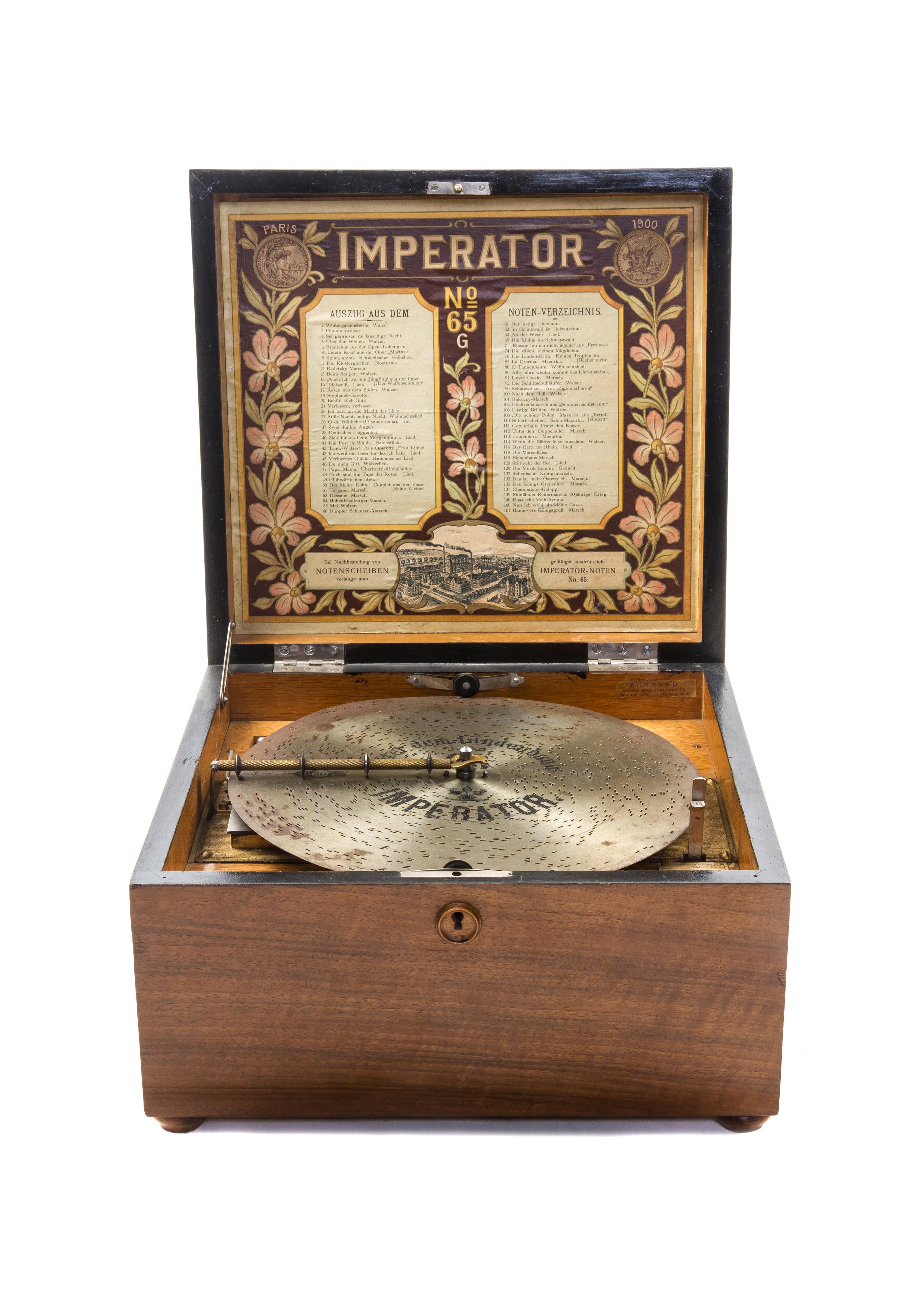 An Imperator Walnut Disk Music Box, Heigth 8 3/8 x width 13 5/8 x depth 13 1/2 inches.