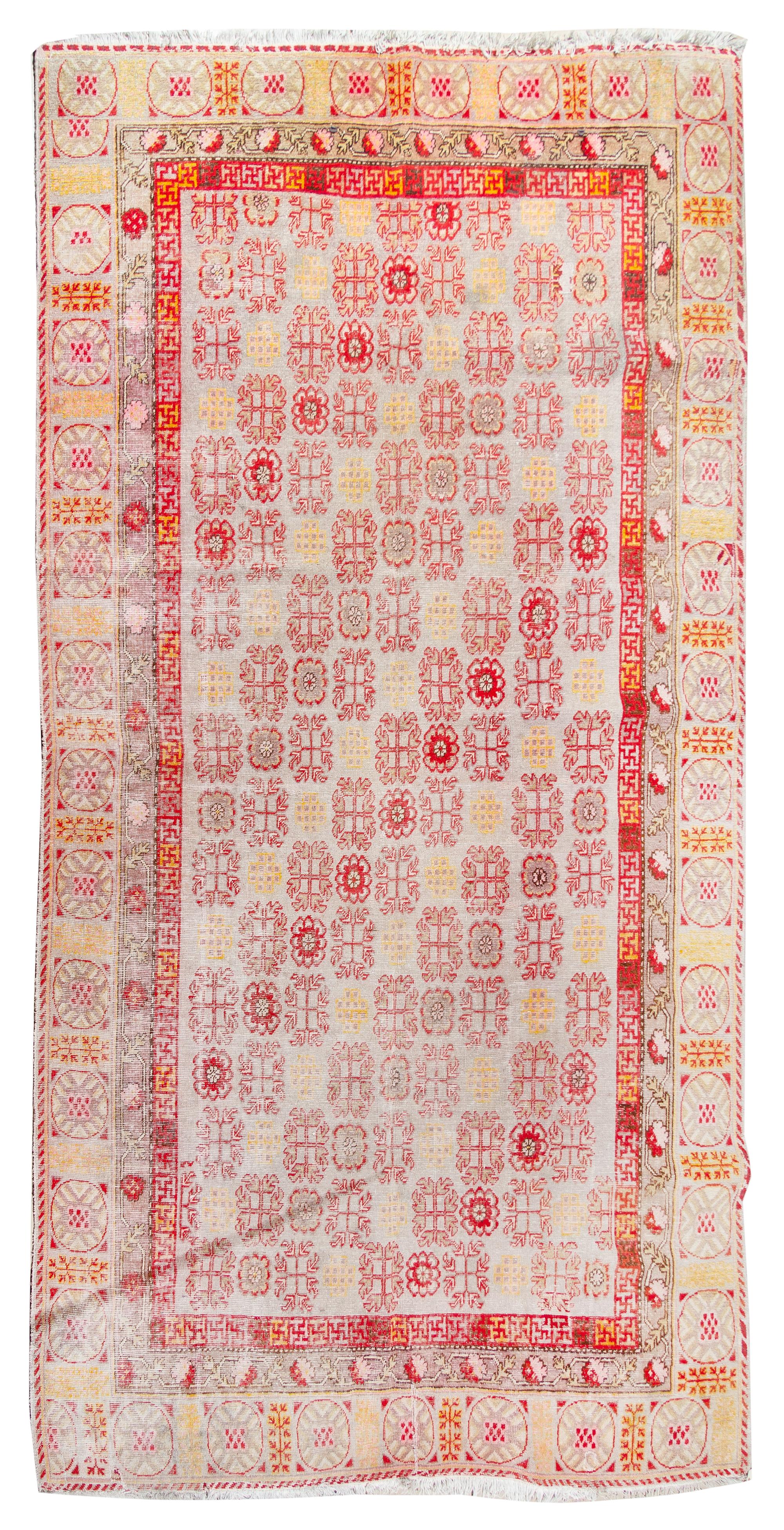 A Khotan Wool Rug 11 feet 9 inches x 6 feet 3 inches. — EAST TURKESTAN, LATE 19TH CENTURY