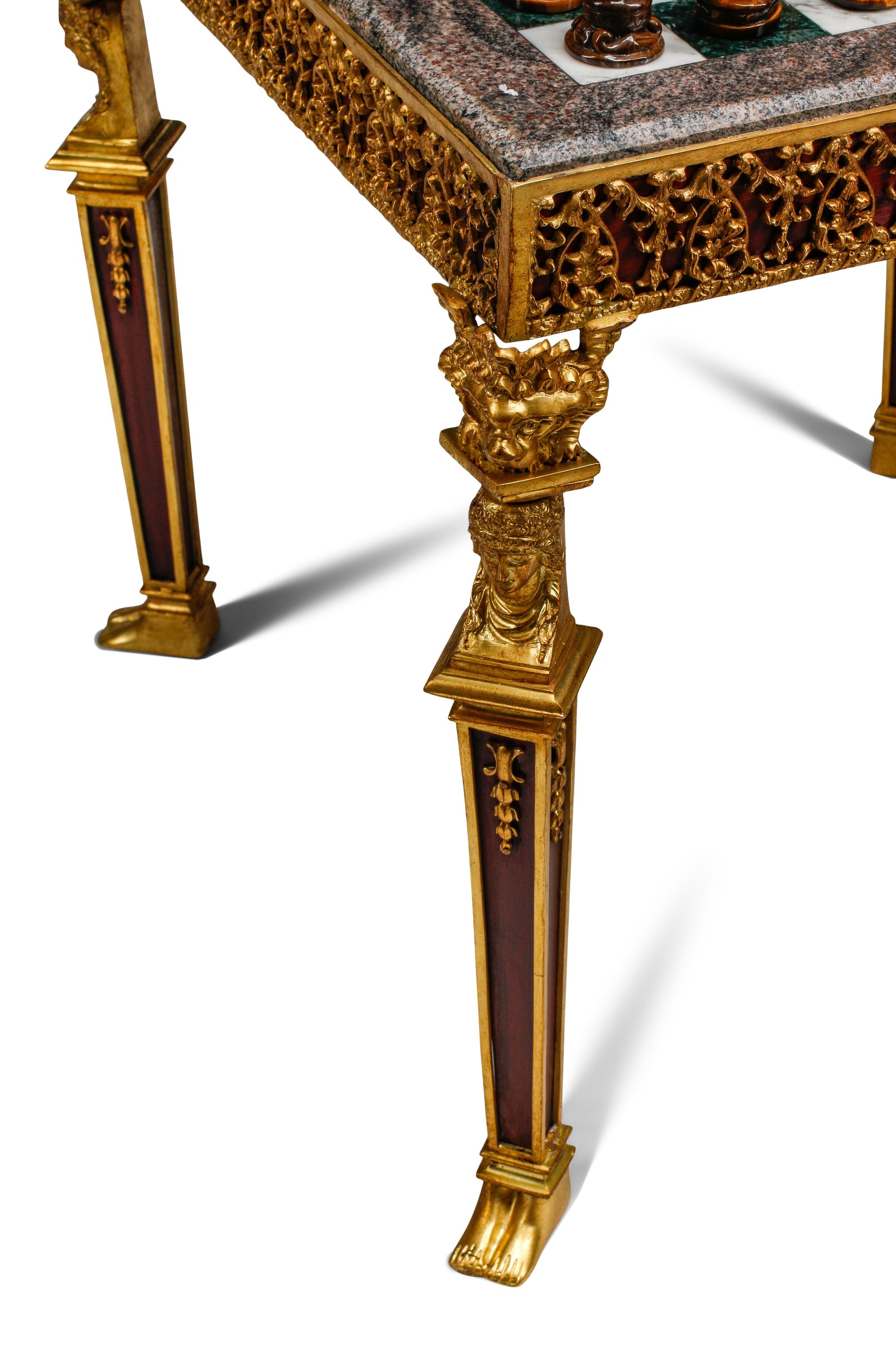 An Empire Style Gilt Bronze Mounted Mahogany and Marble-Top Game Table with a Rock Crystal and Tiger's Eye Chess Set