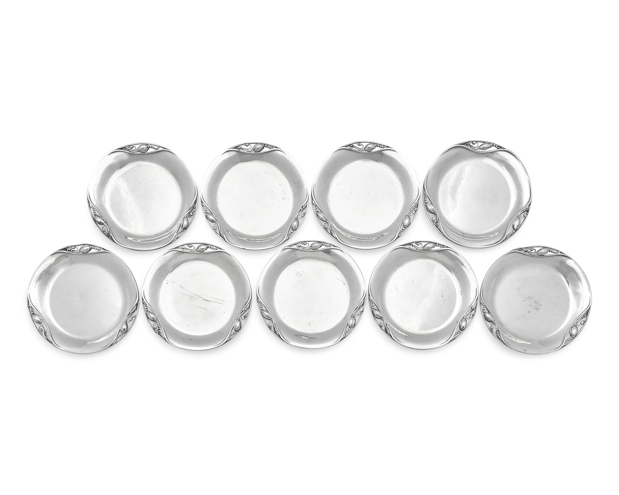 A Set of Nine Georg Jensen Silver Blossom Pattern Bread Plates