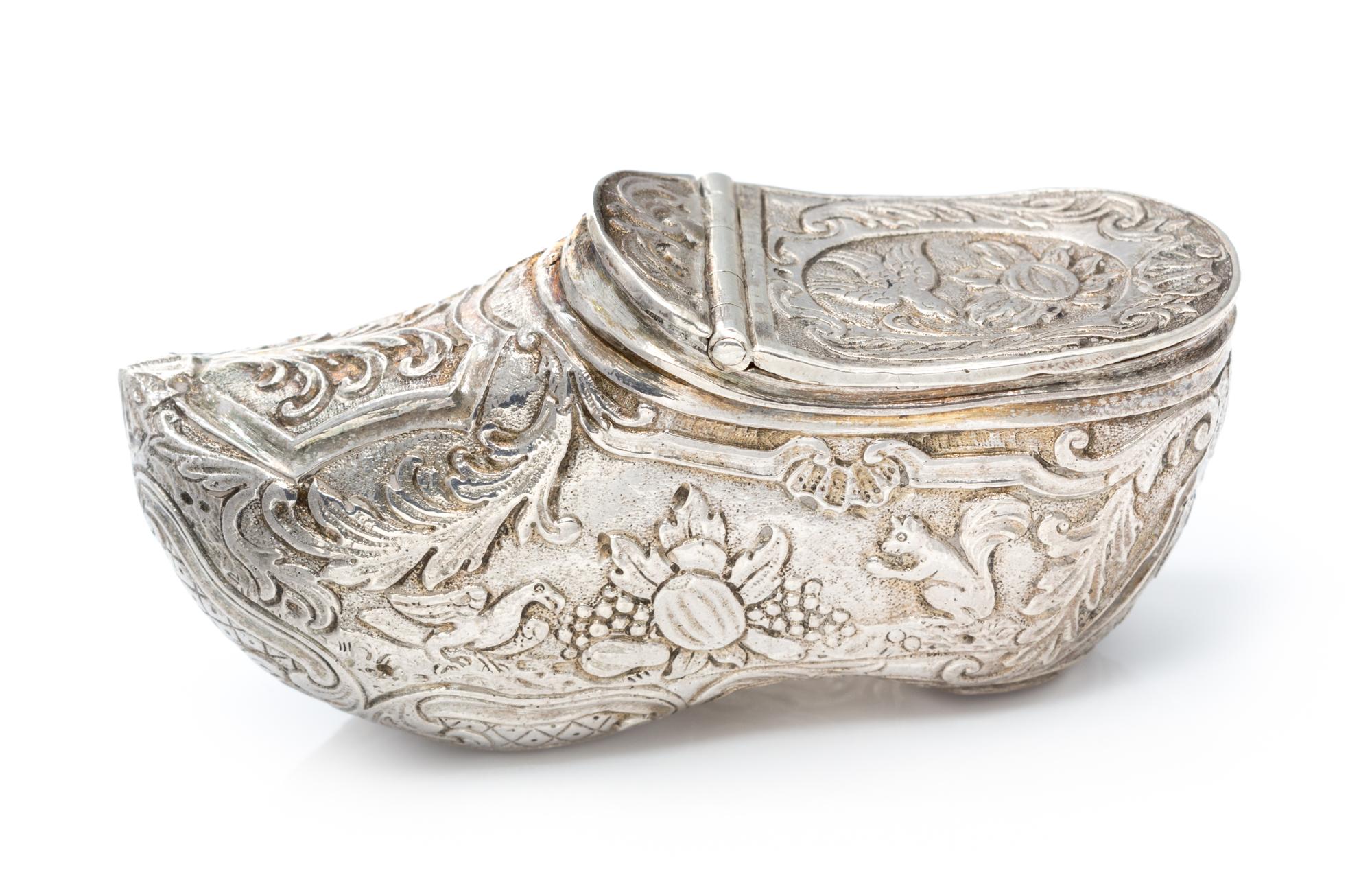 A German Silver Vinaigrette, Maker's Mark Obscured, in the form of a shoe, the exterior chased with floral, foliate and fauna decoratio