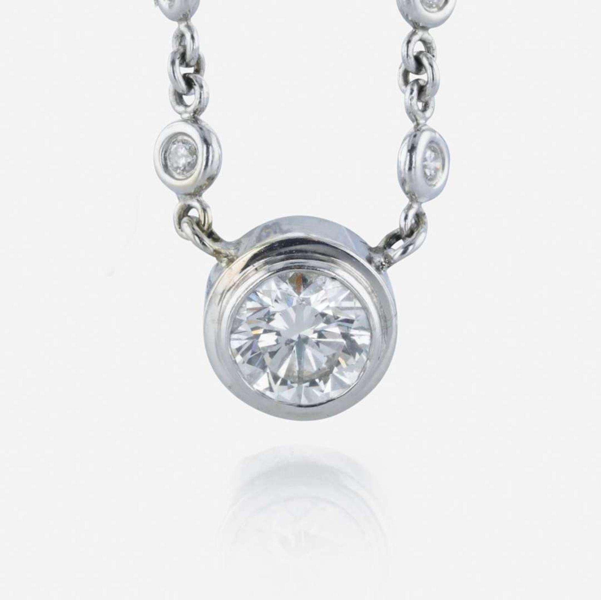 A 14K, white gold diamond bezel set necklace