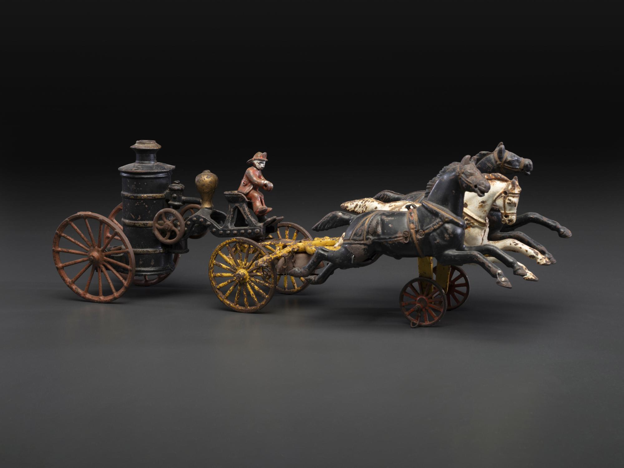 A Painted Cast Iron Three-Horse Fire Pump Wagon Toy