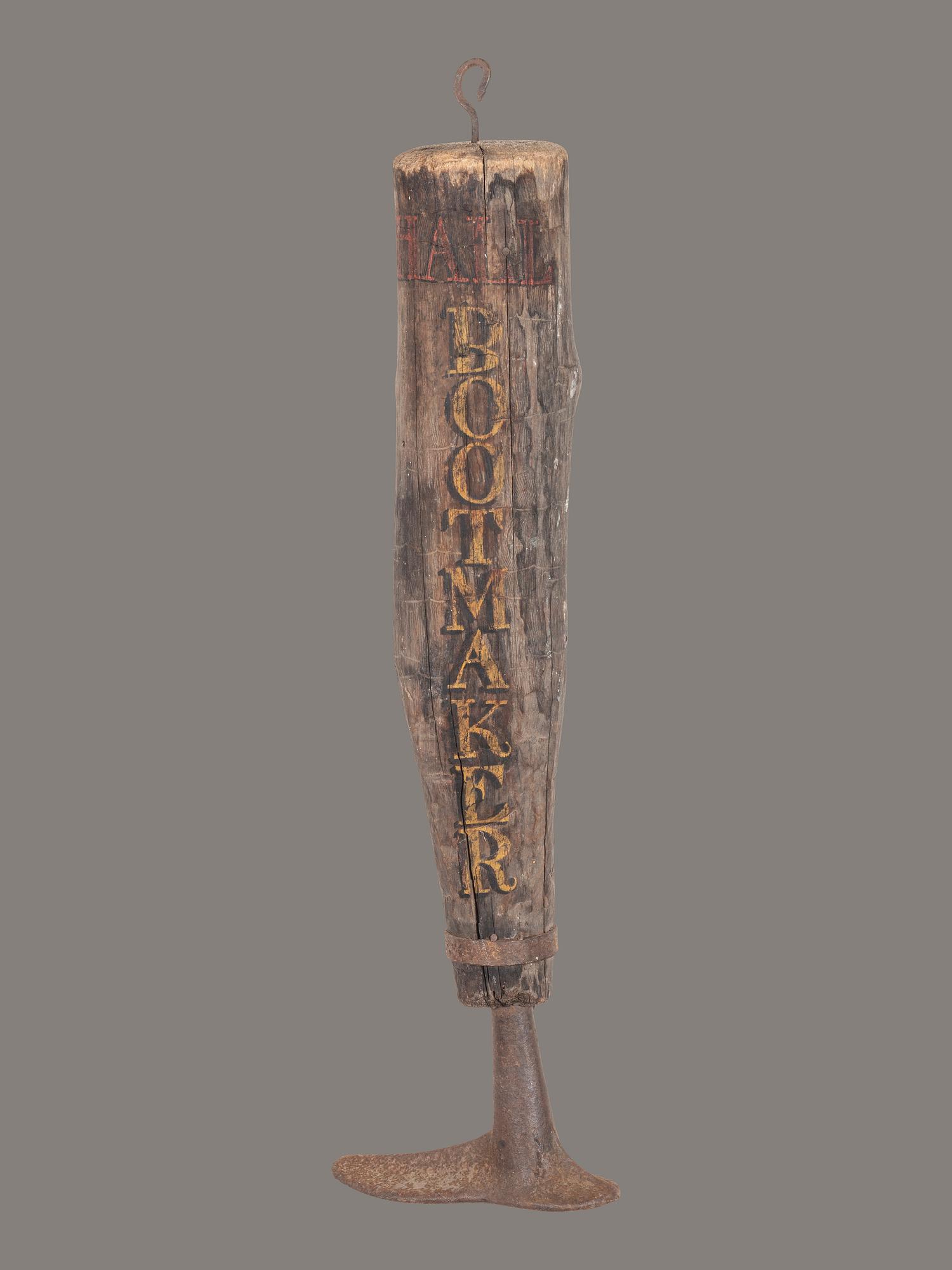 A Carved and Painted Wood and Iron Bootmaker Shop Sign