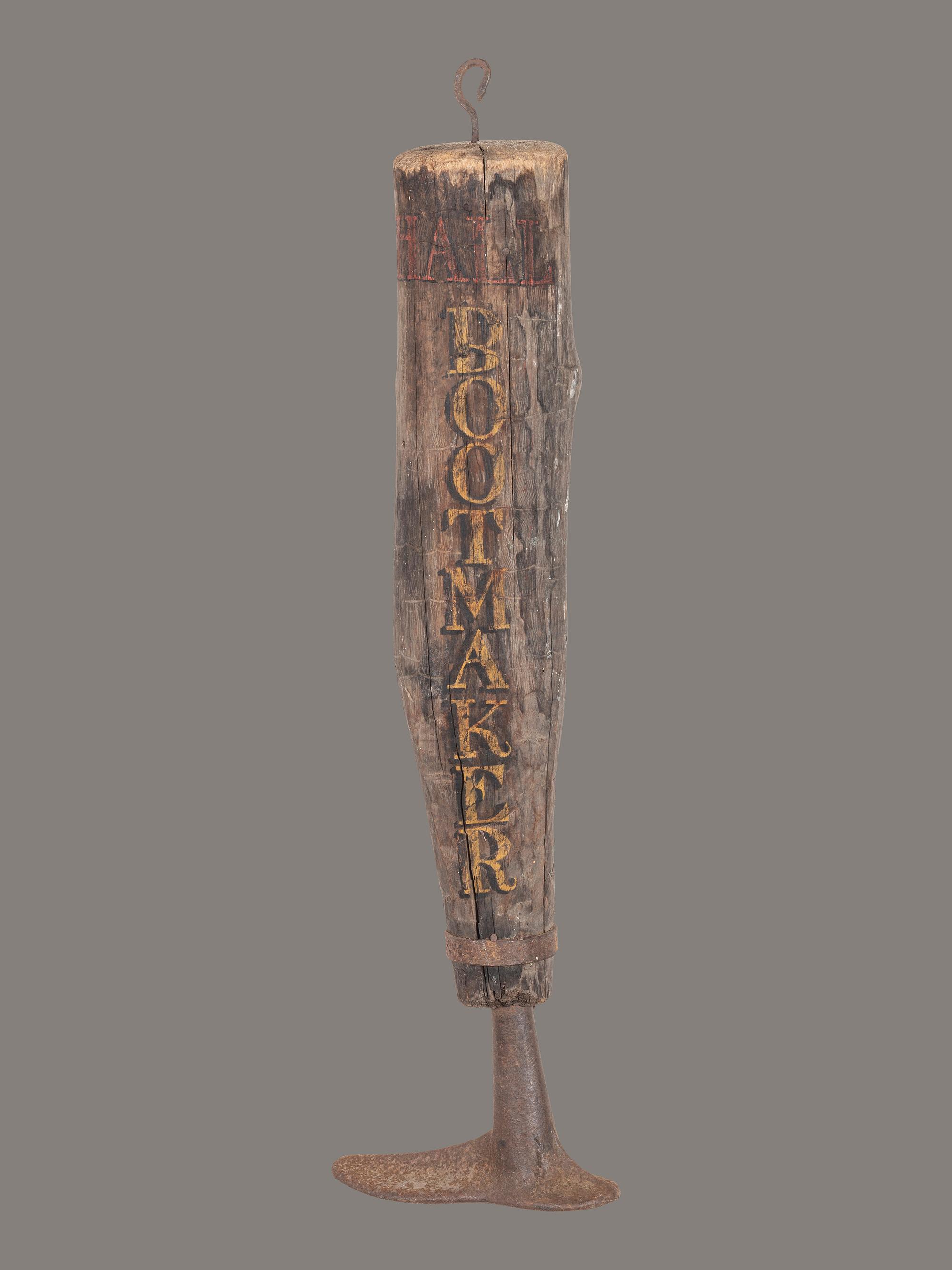 A Carved and Painted Wood and Iron Bootmaker Shop Sign