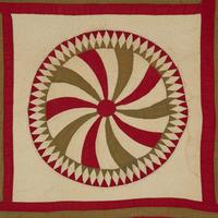 A Pieced Cotton Red and Gold Pinwheel Quilt