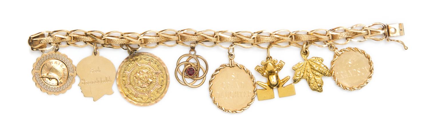A 14 Karat Yellow Gold Charm Bracelet with Eight Attached Charms, 26.20 dwts.