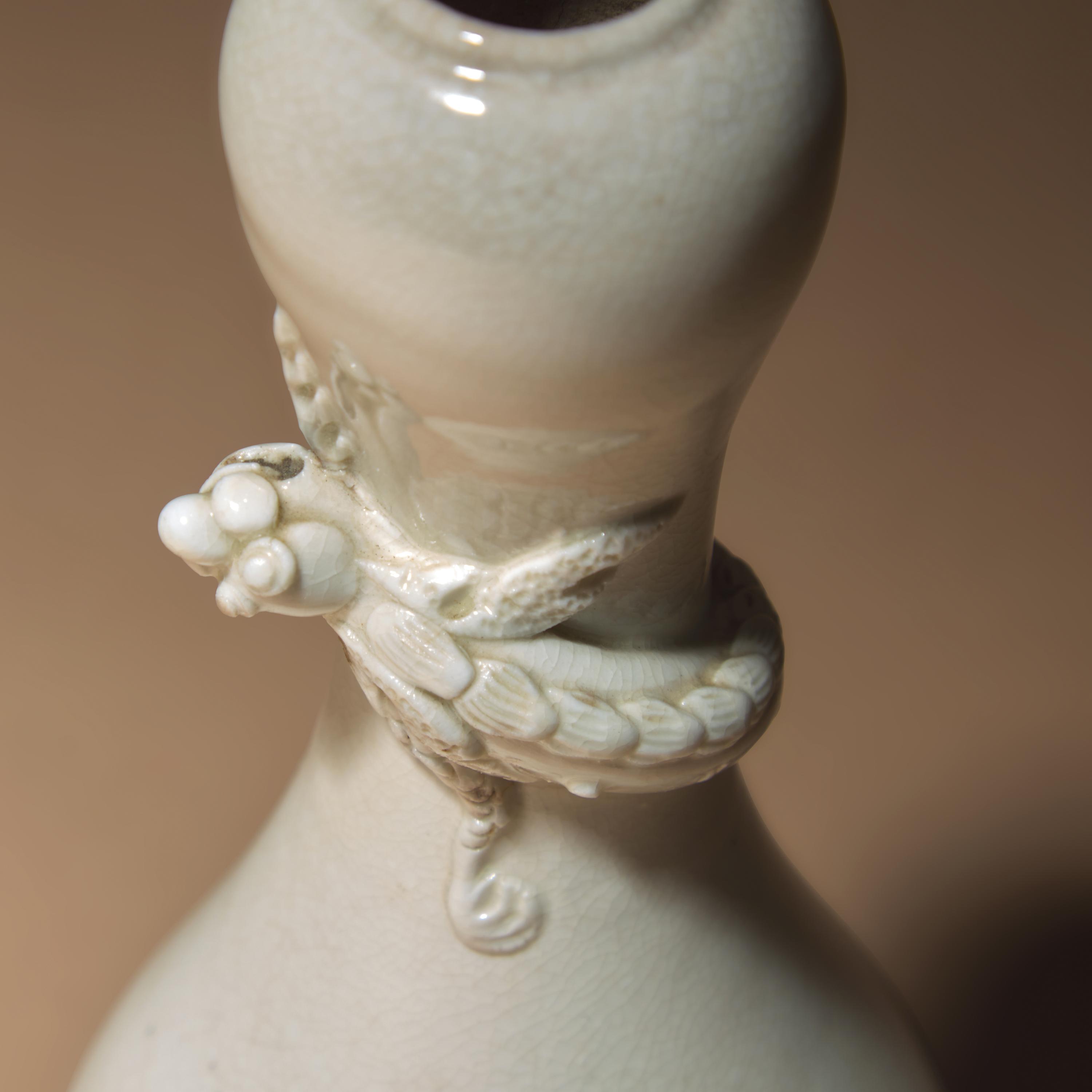 A Chinese White Glazed Porcelain 'Chilong' Bottle Vase, Qing Dynasty — 清 白釉盤螭龍瓶