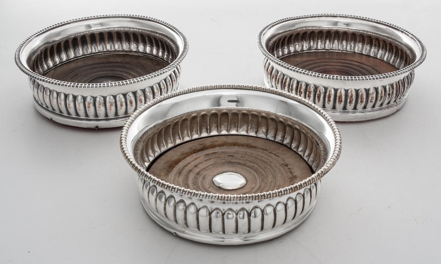 Three Sheffield-plate Wine Coasters, Probably 19th Century, with beaded rims and wood centers, two engraved in center with arm and arro
