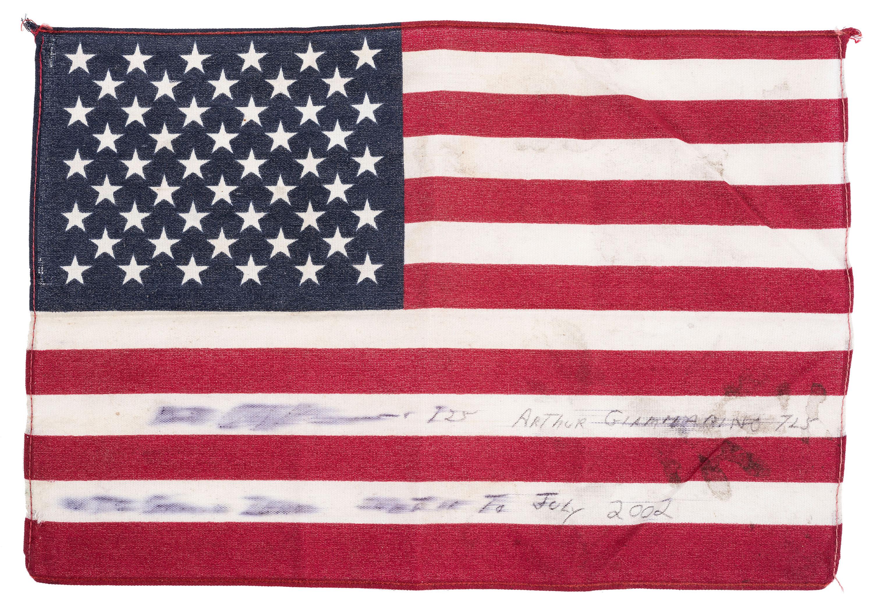 [FLAGS]. A group of items related to the recovery efforts at Ground Zero after September 11, 2011, incl. a helmet worn at the site by retired NYC Detective Arthur Giammarino as he assisted in the recovery efforts.