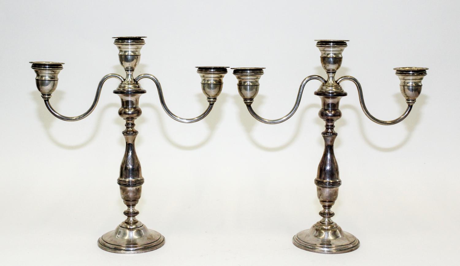 A Pair of American Silver Candlesticks, , having a central urn form cup and two conforming cups issuing S-scroll branches surmounting a