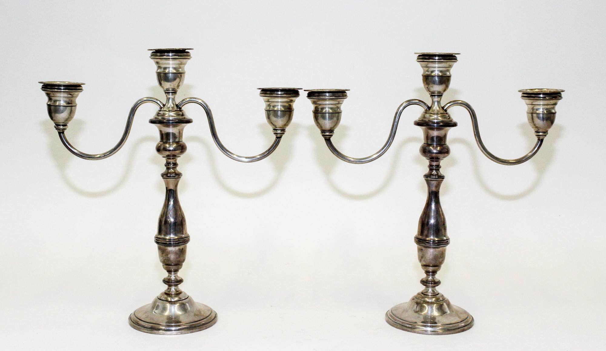A Pair of American Silver Candlesticks, , having a central urn form cup and two conforming cups issuing S-scroll branches surmounting a