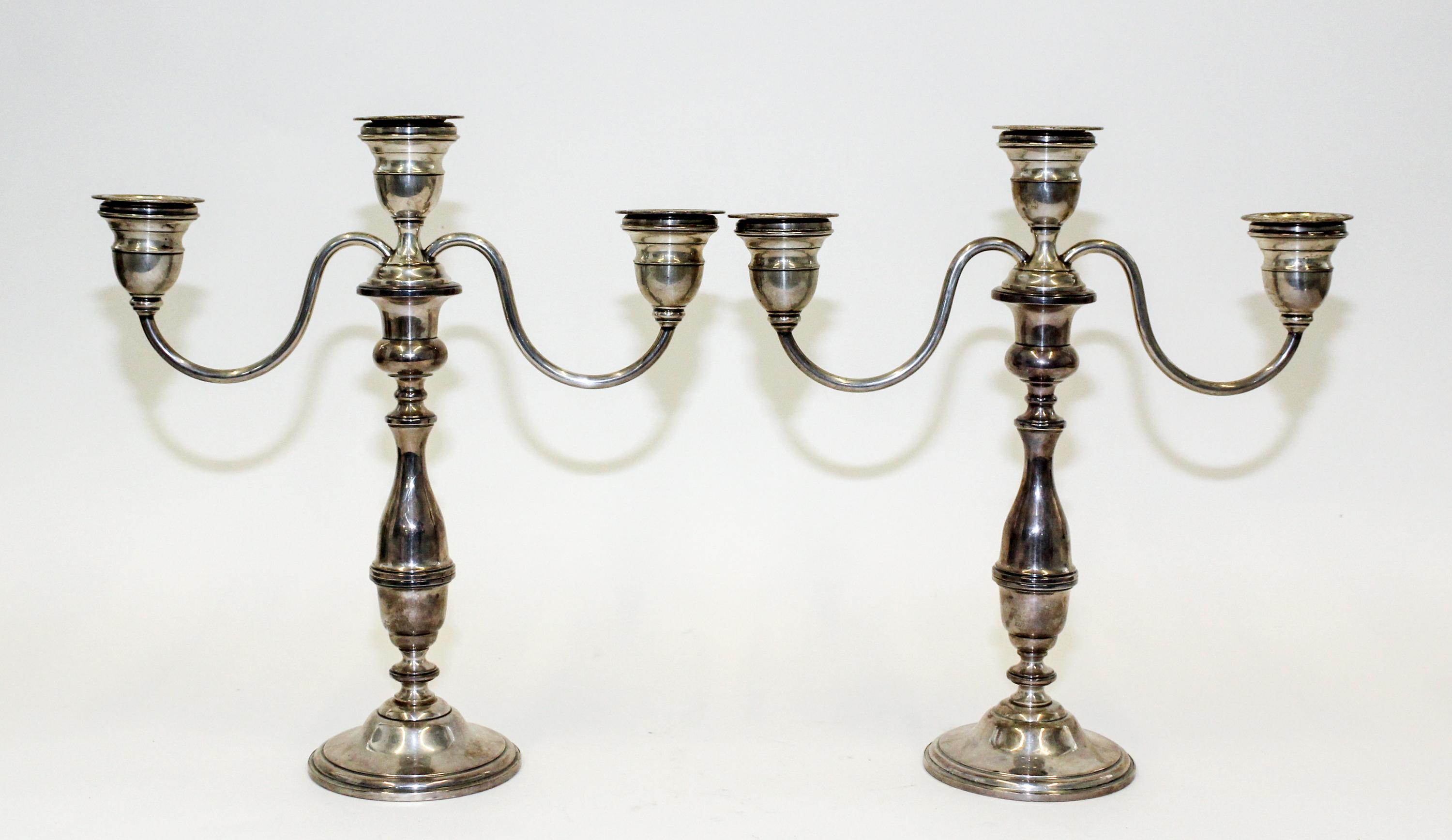 A Pair of American Silver Candlesticks, , having a central urn form cup and two conforming cups issuing S-scroll branches surmounting a
