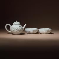 A Chinese Blanc-de-Chine Molded Porcelain Covered Teapot and a Pair of Molded Floriform Bowls, 18th Century — 清中期 德化白瓷貼塑松鼠葡萄茶壺及茶碗一對