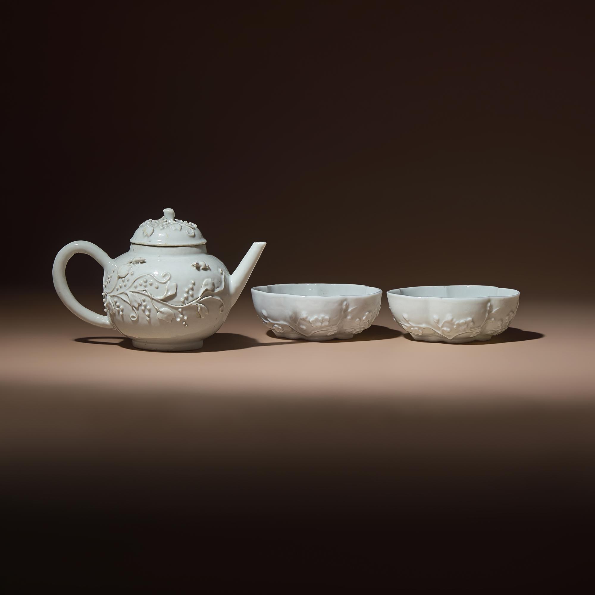 A Chinese Blanc-de-Chine Molded Porcelain Covered Teapot and a Pair of Molded Floriform Bowls, 18th Century — 清中期 德化白瓷貼塑松鼠葡萄茶壺及茶碗一對