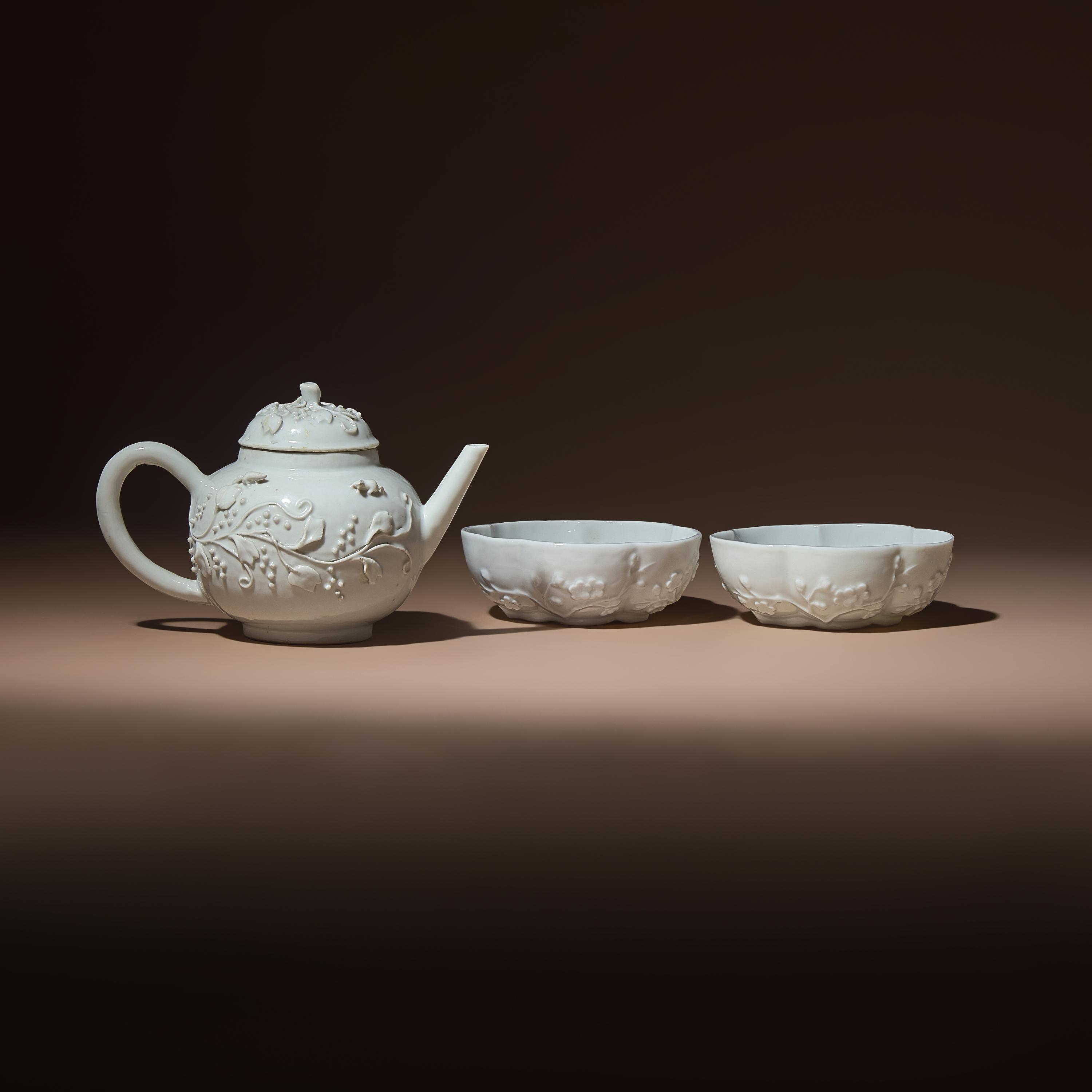A Chinese Blanc-de-Chine Molded Porcelain Covered Teapot and a Pair of Molded Floriform Bowls, 18th Century — 清中期 德化白瓷貼塑松鼠葡萄茶壺及茶碗一對