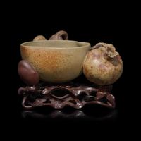 A Rare Chinese Yixing 'Peach and Pomegranate' Coupe Inscribed 'Chen Minyuan Zuo' and Carved Wood Stand 陳鳴遠款段泥紫砂桃榴杯