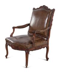 A Régence Style Carved Walnut Fauteuil with Leather Upholstery