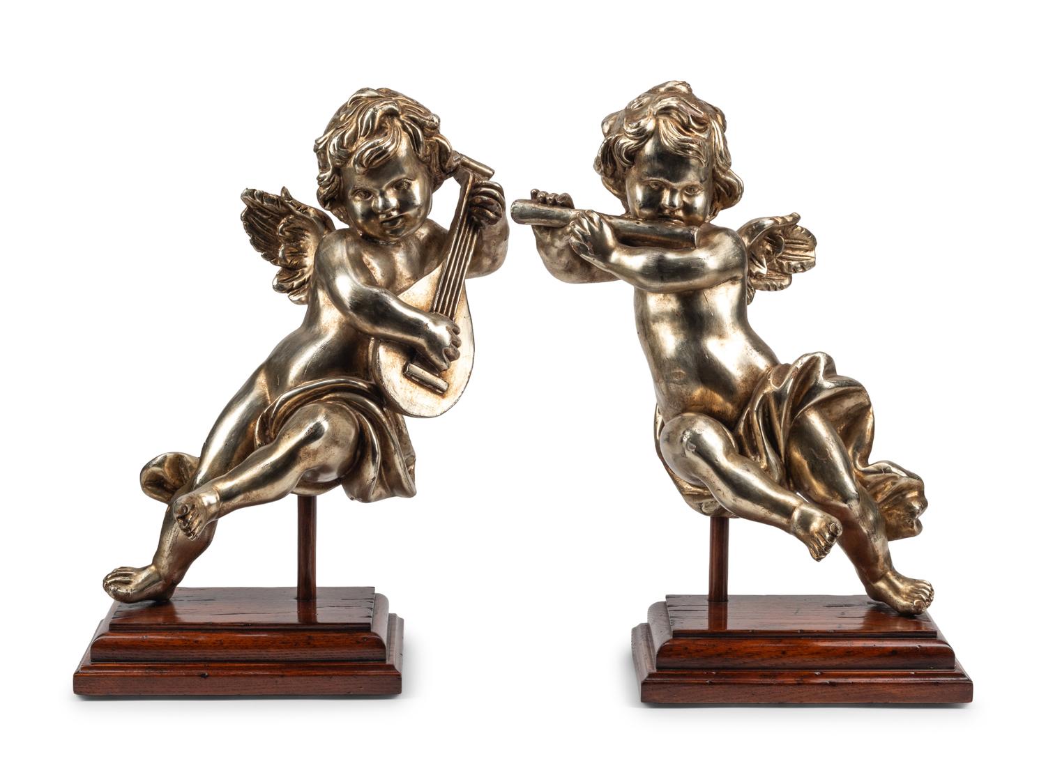 A Pair of Silvered Wood Musical Putto Ornaments