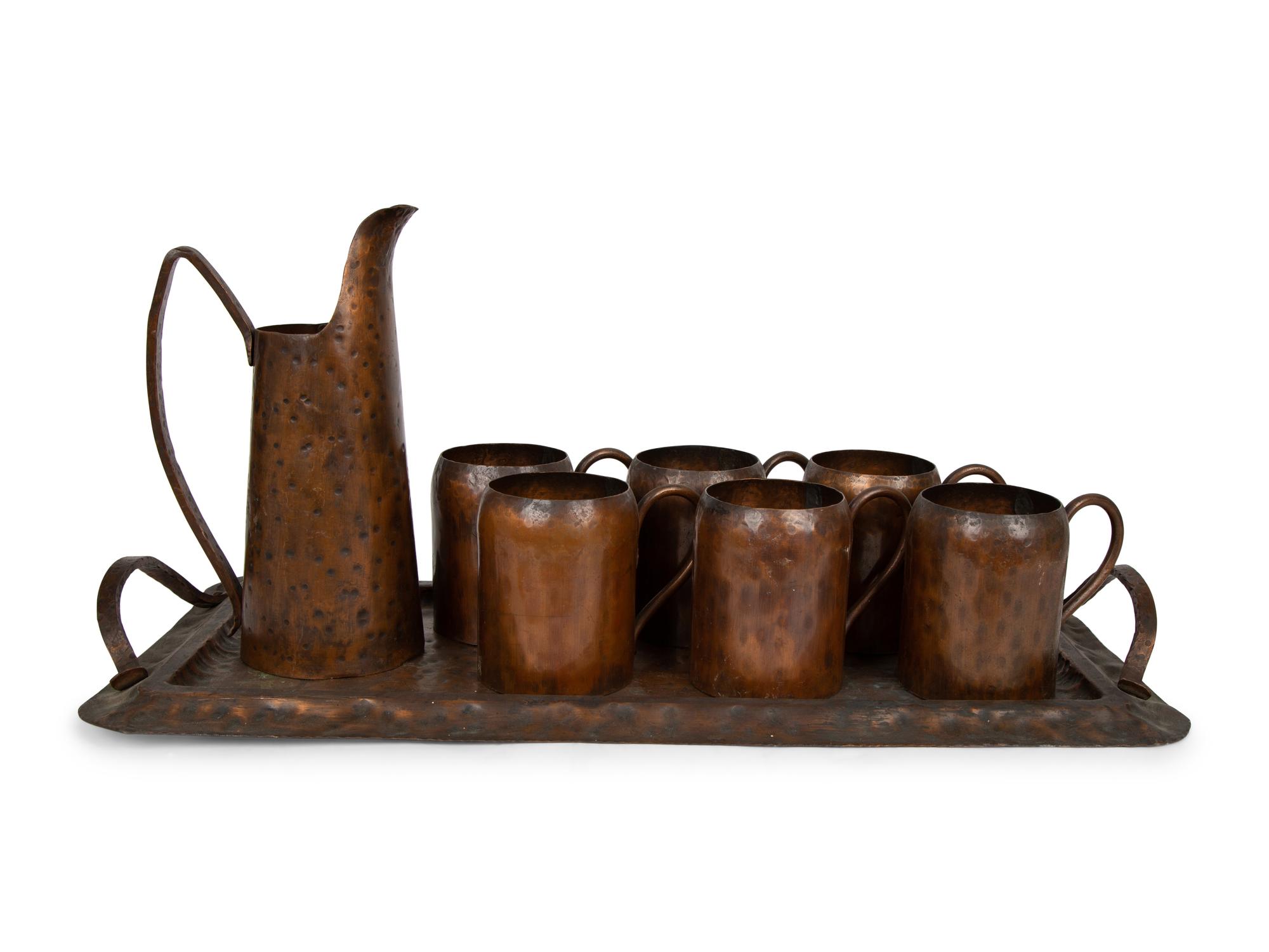 An Arts & Crafts Style Hand Hammered Copper Tray, Pitcher, and Six Mugs — 20TH CENTURY