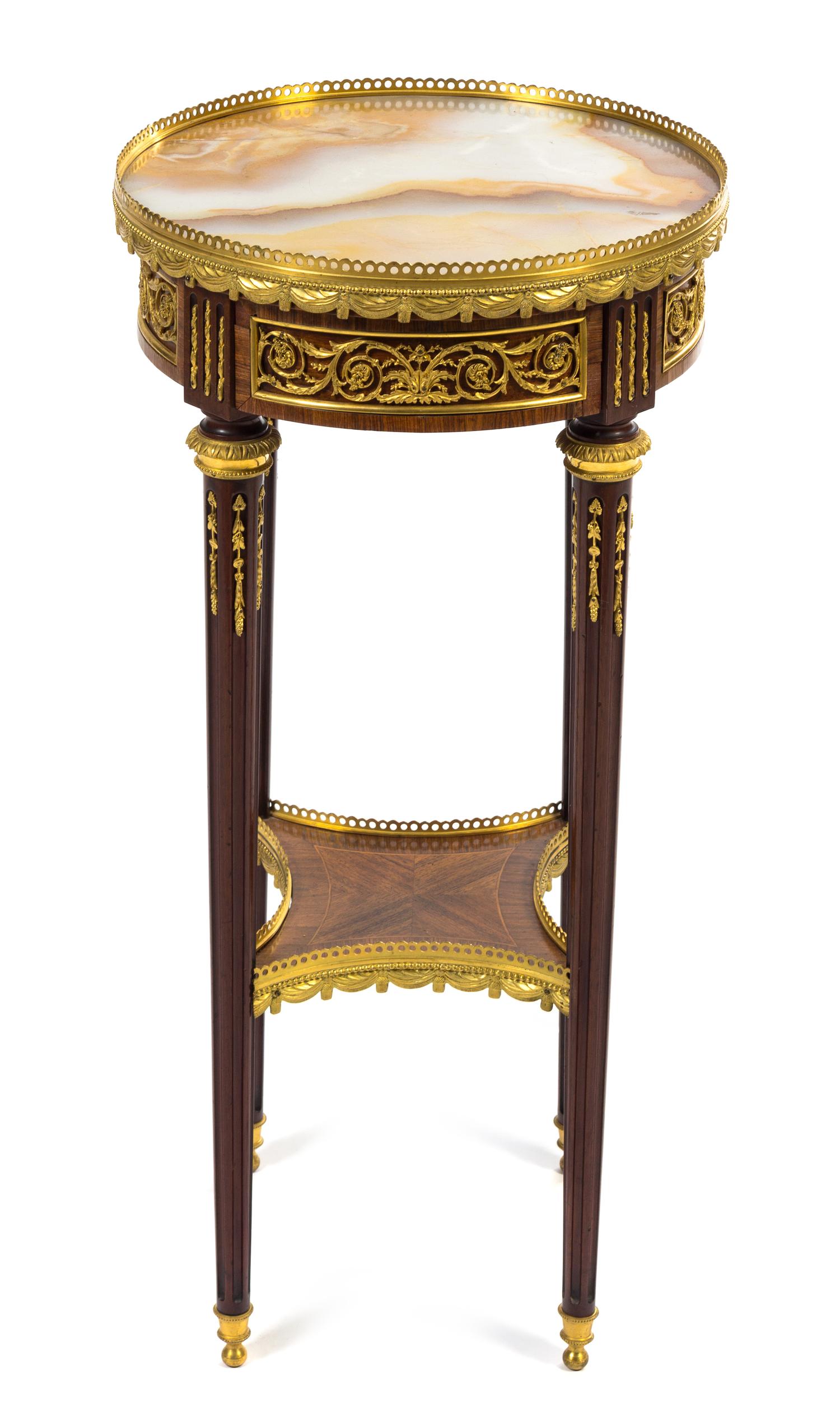 A Louis XVI Style Gilt Bronze Mounted Mahogany and Fruitwood Table Height 29 1/4 x diameter of top 14 1/2 inches. — LATE 19TH CENTURY