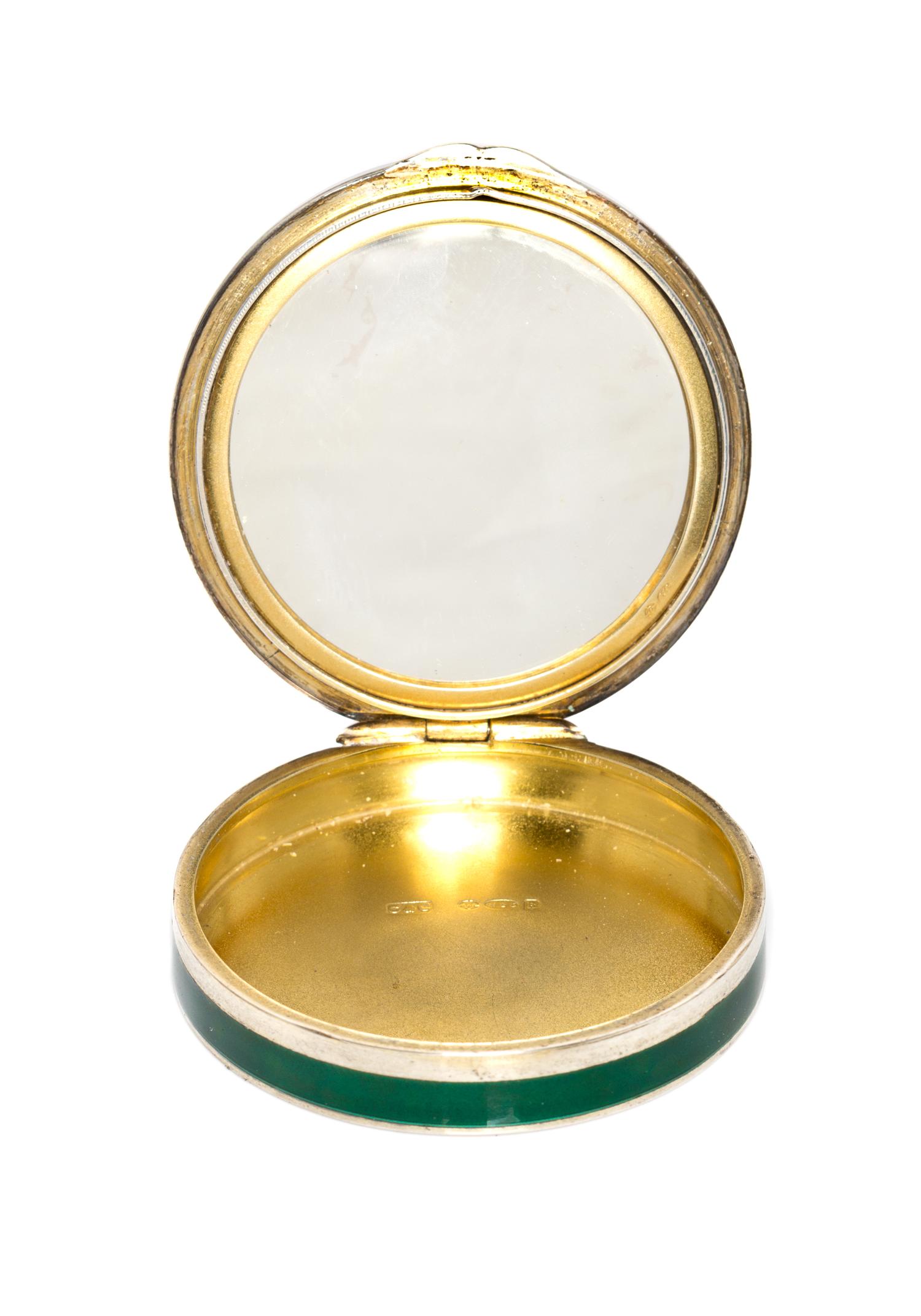 A Continental Silver and Enamel Compact, Import Mark C&C, London, 1925, of circular form, the lid with gilt and red foliate elements on