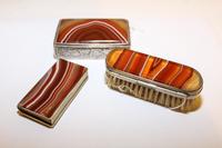 Three Silver and Agate Dresser Articles, Late 19th Century, comprising a match strike, a box and a brush with a compact and mirror.