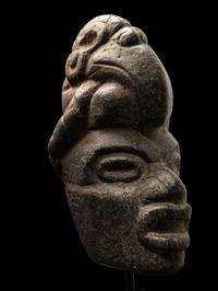 A Maya Stone Hacha of a Warrior Wearing a Helmet in the Form of a Macaw
