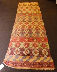 A Kilim Flatweave Wool Rug 11 feet 4 inches x 2 feet 9 inches. — EARLY TO MID 20TH CENTURY