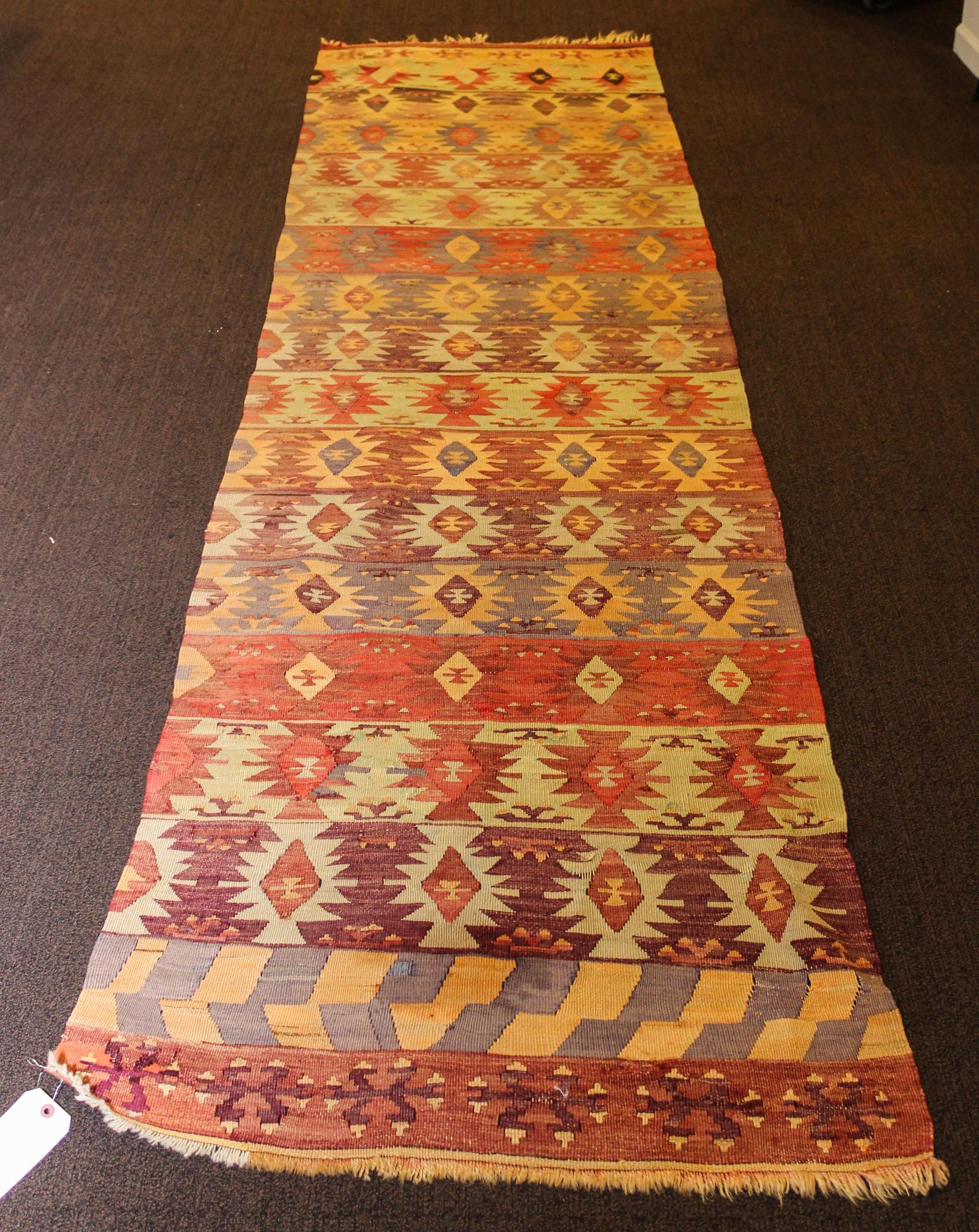 A Kilim Flatweave Wool Rug 11 feet 4 inches x 2 feet 9 inches. — EARLY TO MID 20TH CENTURY