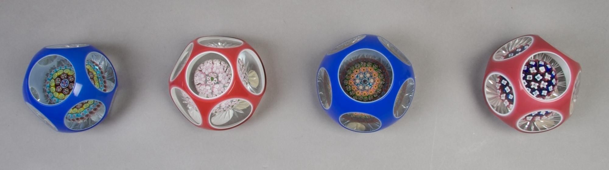 A Collection of Four Cased Glass Paperweights, Diameter 3 1/2 inches.