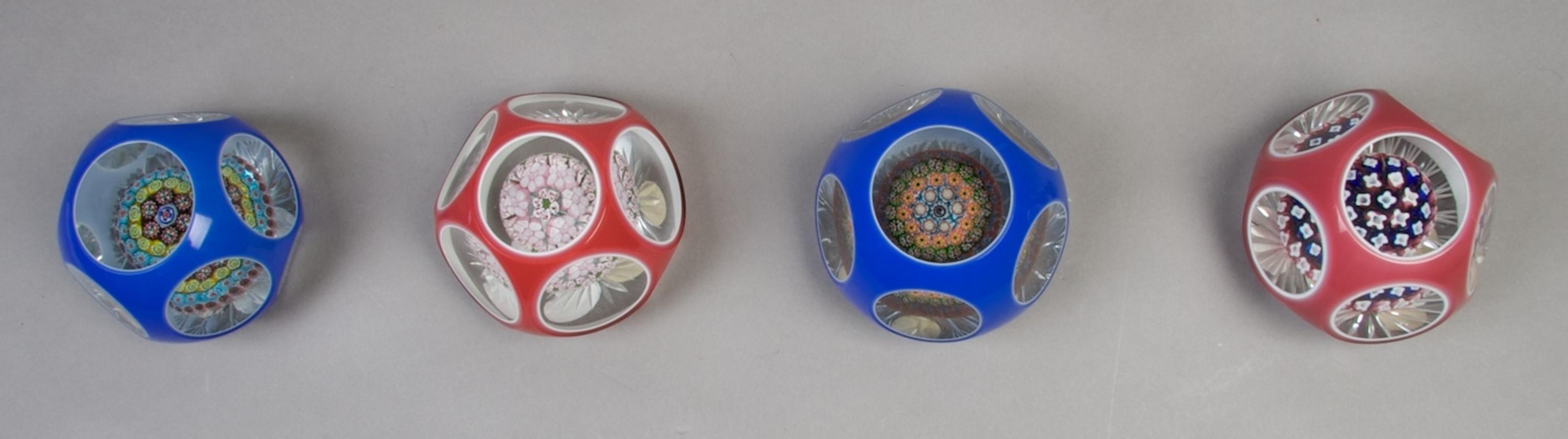 A Collection of Four Cased Glass Paperweights, Diameter 3 1/2 inches.