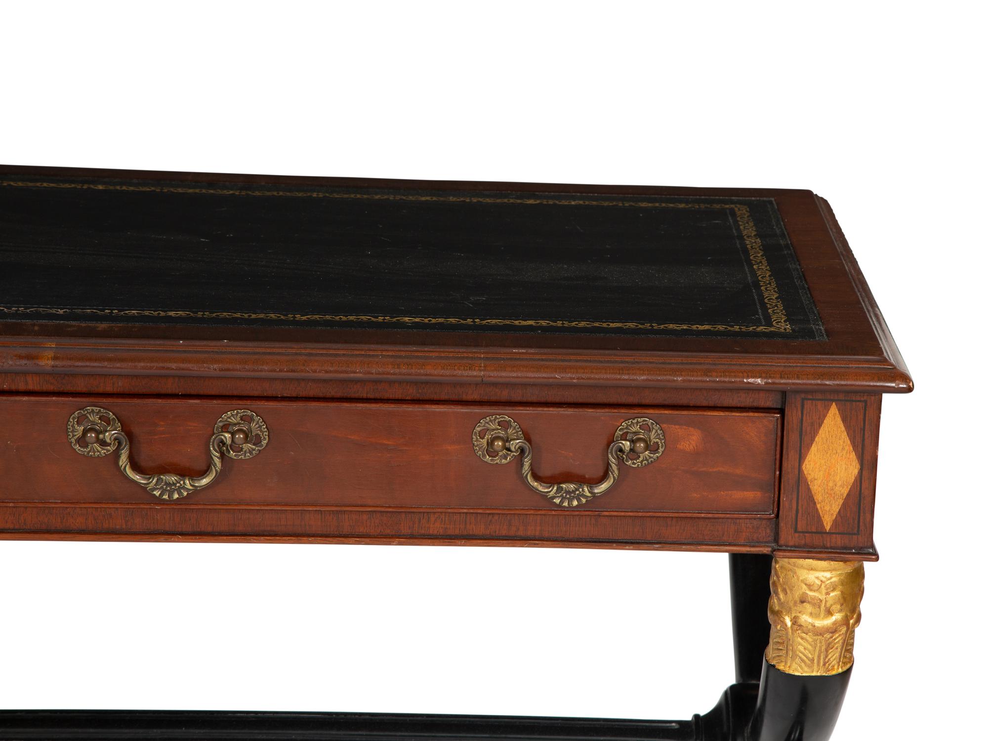 A Regency Style Parcel Gilt and Ebonized Mahogany Leather Top Console Table